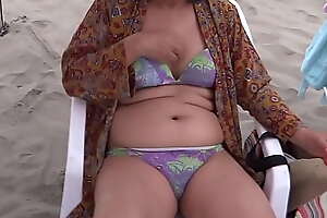 My Latin wife, beautiful 58-year-old mother enjoys the beach, shows off, shows her hairy pussy of hers in a bikini, she masturbates, intense orgasms, cumshot on her delicious body